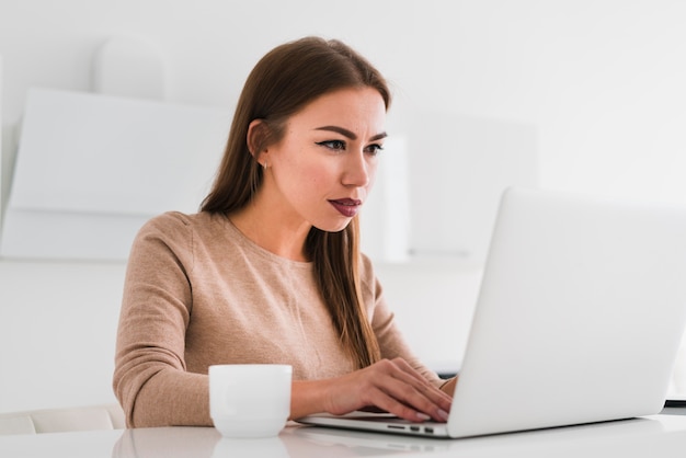 Photo woman working and having a cup of coffee