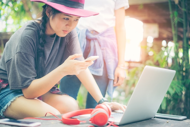 コーヒーショップでラップトップと携帯電話で働く女性