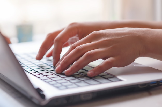 Woman working at home office hand on keyboard close up