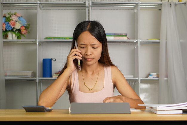 집에서 일하는 여성: 드폰과 컴퓨터를 사용하여 팀 동료와 통신하십시오.