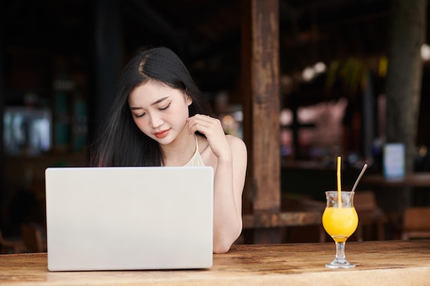 Woman Working on Laptop at Beach Bar