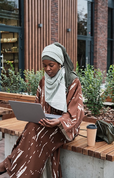 Женщина, работающая на ноутбуке в городе