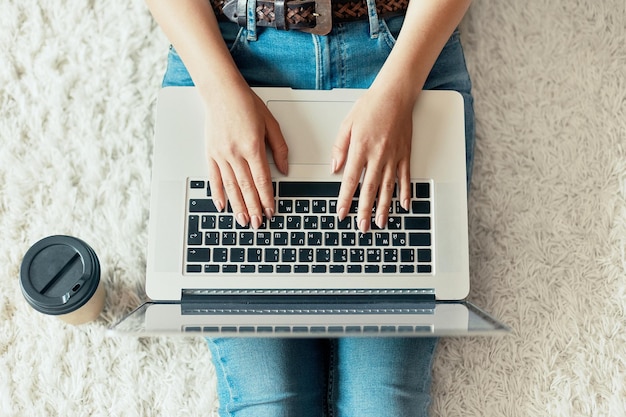 Woman working on a laptop Female using a laptop sitting on floor searching web browsing