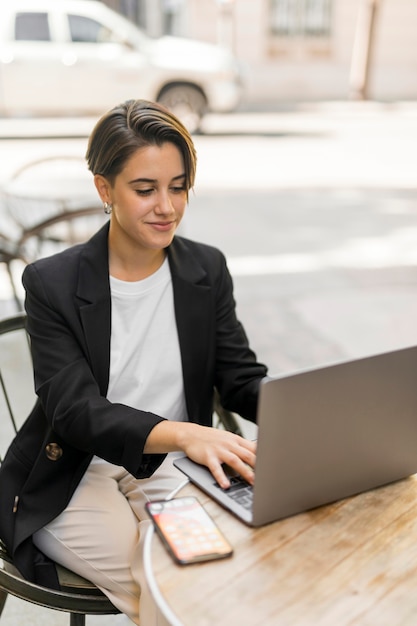 Woman working on laptop outdoors