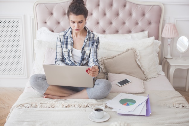 Woman working on laptop. Remote worker indoors.