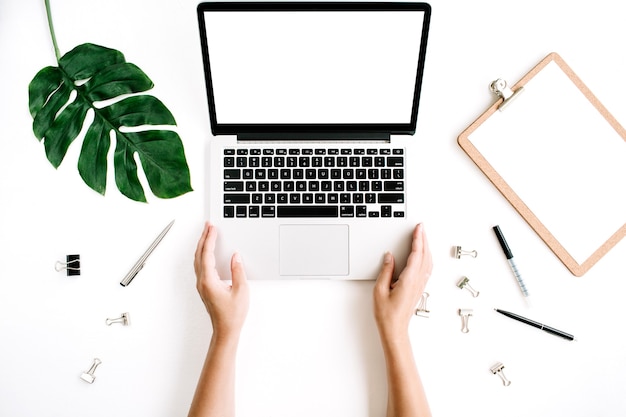 Woman working on laptop with blank screen workspace