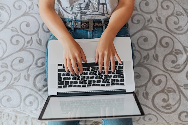 Donna che lavora al computer portatile e che scrive vista dall'alto