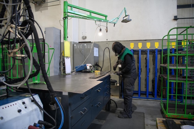 a woman working in the modern metal production and processing industry welding the product and prepares it for a cnc machine. high quality photo
