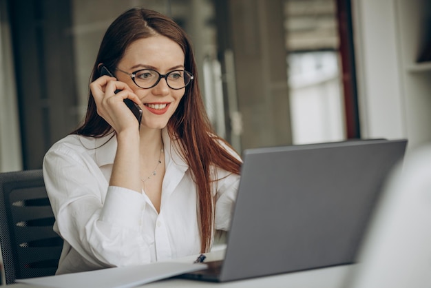 コンピューターでオフィスで働く女性