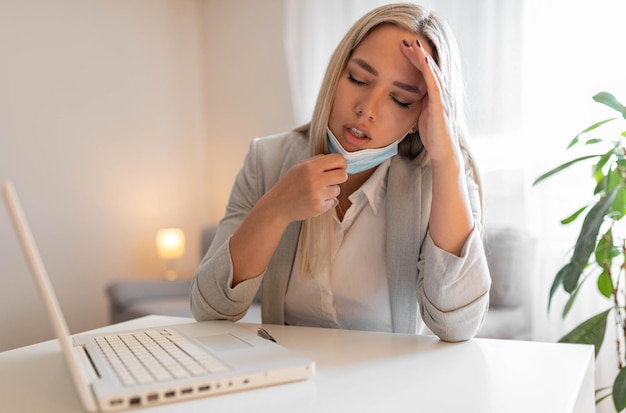 Woman working in the office and having difficulties breathing
with face mask