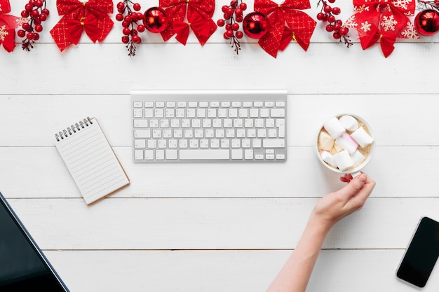 Woman working at an office table with christmas festive decorations