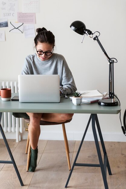 写真 自宅でラップトップで作業する女性