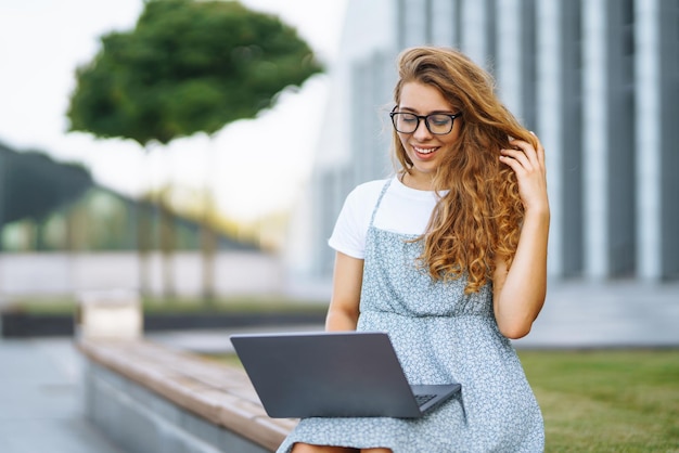 노트북 컴퓨터에서 온라인으로 일하는 여성 야외 비즈니스 블로 프리랜서 교육 개념