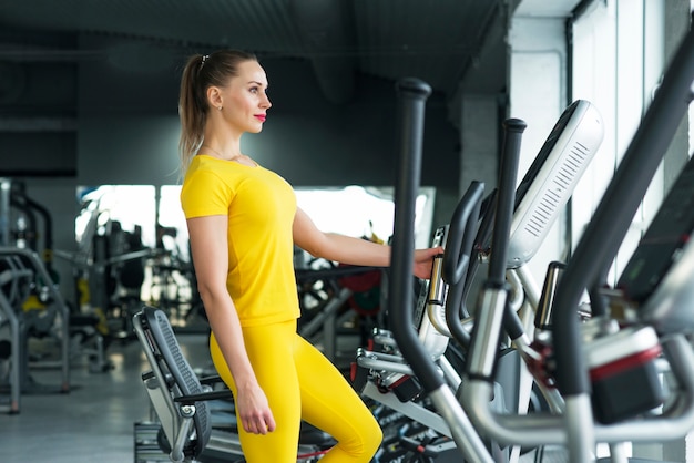 Woman Working Out On Elliptical Machine in gym