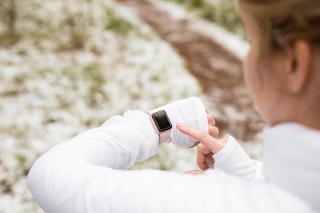 Фото Женщина тренируется на улице и проверяет свои цифровые часы