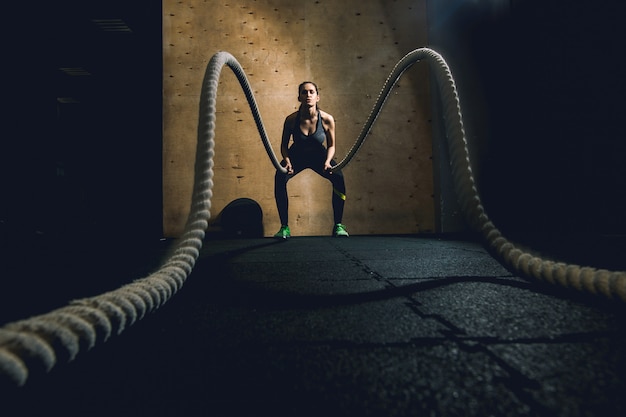 Woman working out with battle ropes