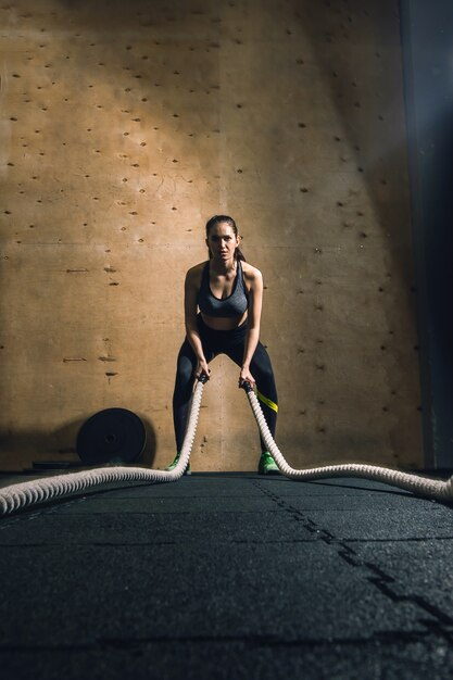 Woman working out with battle ropes