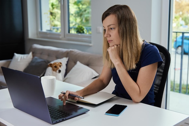 노트북을 사용하여 홈 오피스에서 원격으로 일하는 여성