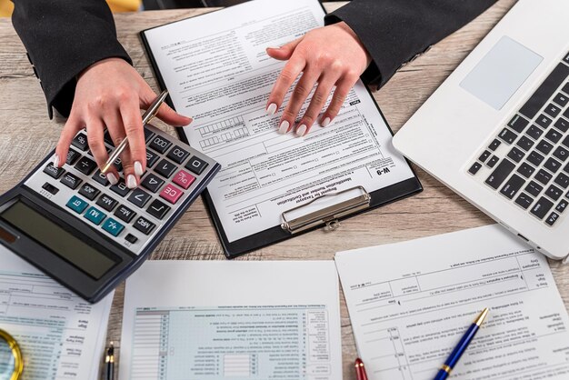 Женщина, работающая с документом бизнес-отчета, заполняющая налоговую форму, учитывающая время для налога