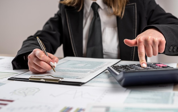 Woman working with business report document filling tax form accounting