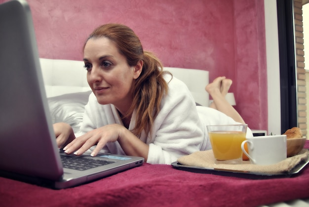 Женщина работает с компьютером в своей комнате тихо