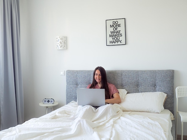 Woman working with laptop on the bed