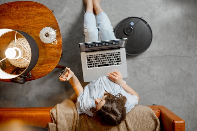 Woman working with laptop and smartphone from home