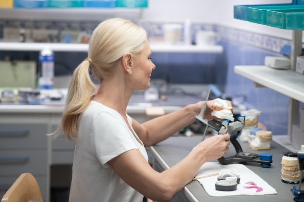 A woman working with medical plaster and making dental prosthesis