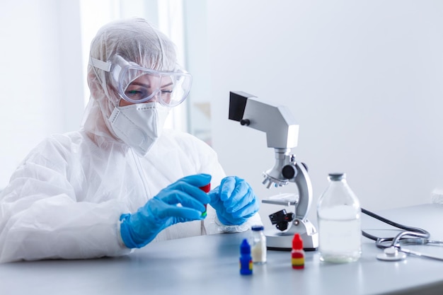 Donna che lavora con un microscopio in laboratorio