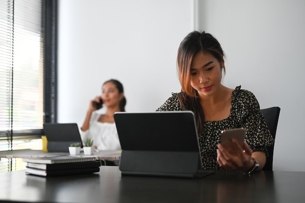 タブレットと携帯電話で働く女性