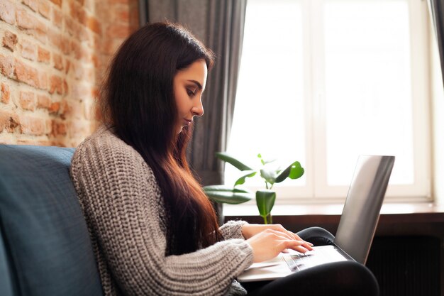 Woman works at home on a laptop during a worldwide virus epidemic