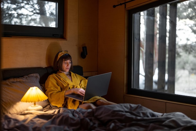 Woman works on laptop in bedroom