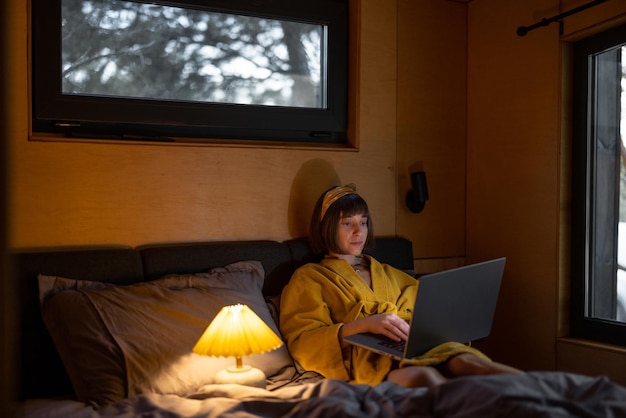 Woman works on laptop in bedroom