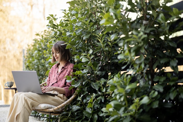 La donna lavora al computer portatile in giardino