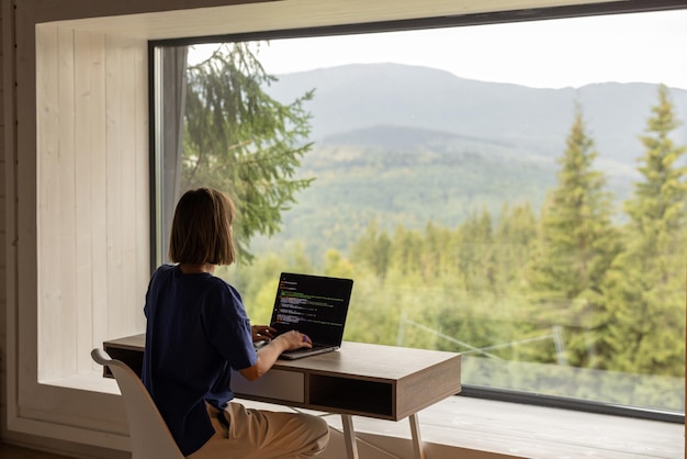 Foto la donna lavora al computer portatile a distanza in casa sulla natura