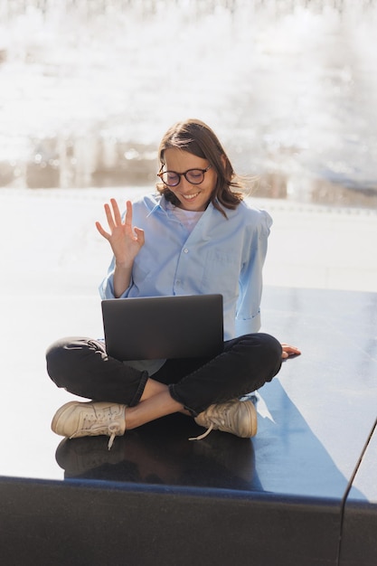 写真 女性は夏に屋外のラップトップで動作します ビジネス人は噴水のそばに座っています