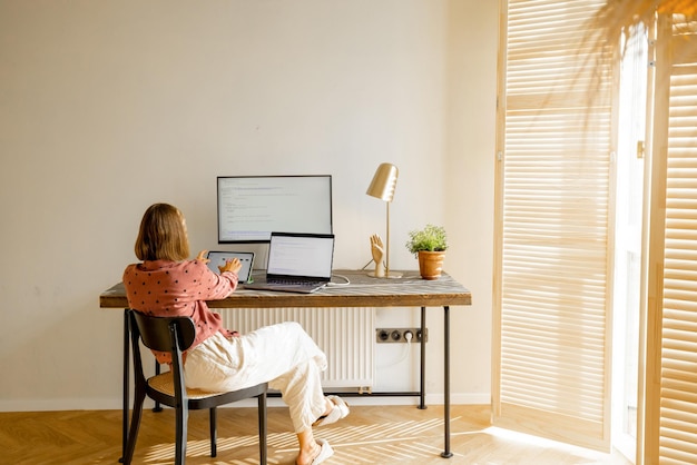 Woman works online on computers at home