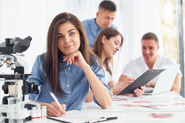 Woman works with document Group of young doctors is together in the office