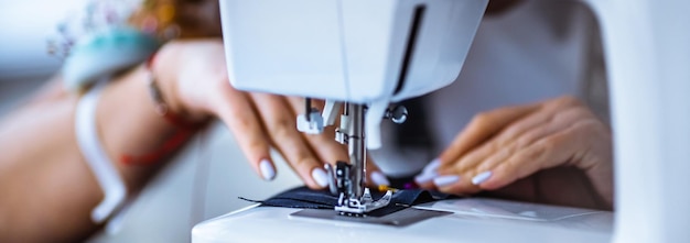 The woman works with a piece of cloth on the sewing machine