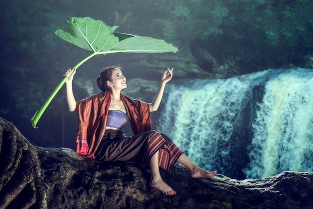 Woman wrapped in fabric sitting on rock