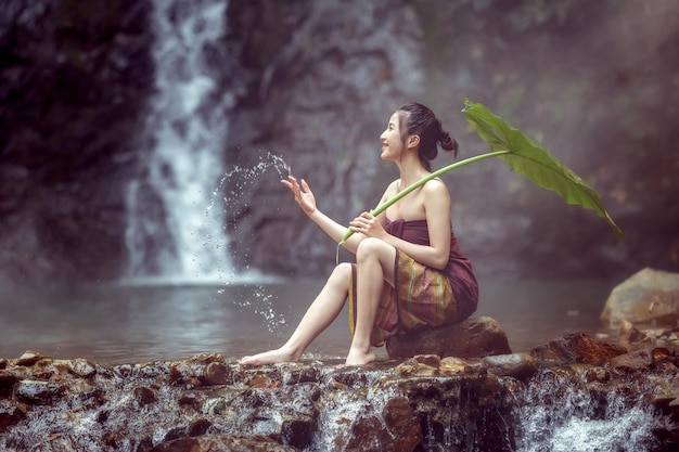 Woman wrapped in fabric sitting on rock