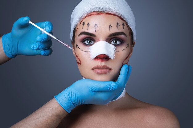 Woman wrapped with bandages and scars  is prepared for another one operation.