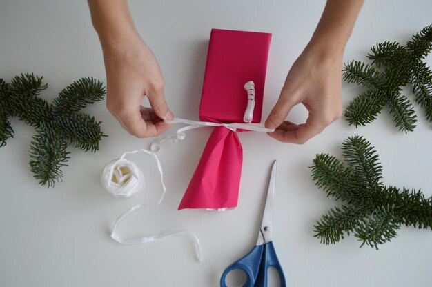 Foto donna che avvolge un regalo di natale sul tavolo