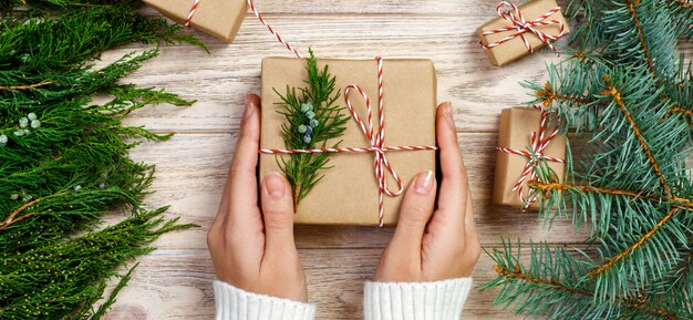 Woman wrapping modern Christmas gifts presents at home