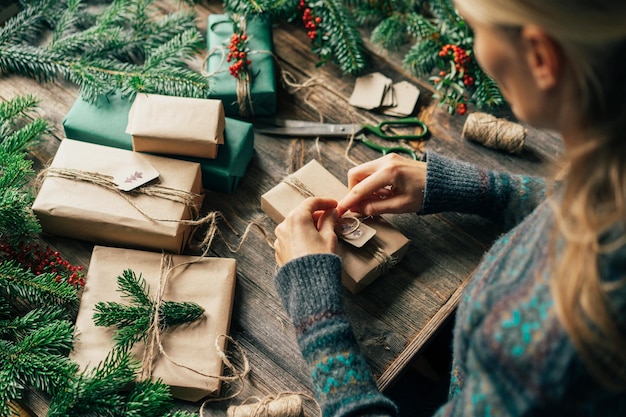 アドベント・クリスマス・イブのプレゼントを包む女性と新年の祝賀の装飾を手作りする女性
