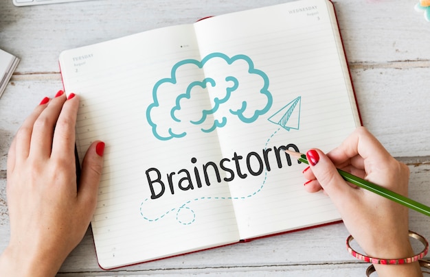 Woman writing Brainstorm on a notebook