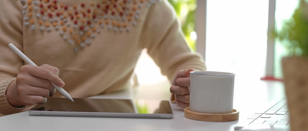 Woman writing on digital tablet