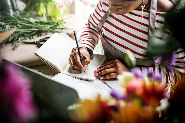 Woman writing down a list on a notebook