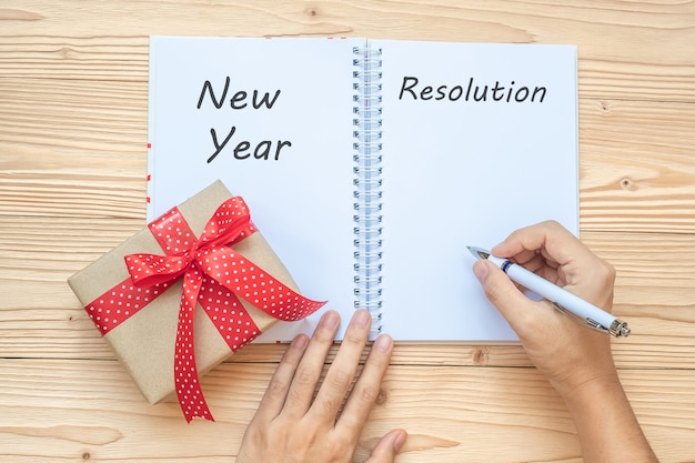 Foto la donna che scrive le risoluzioni di anno nuovo esprime con il taccuino