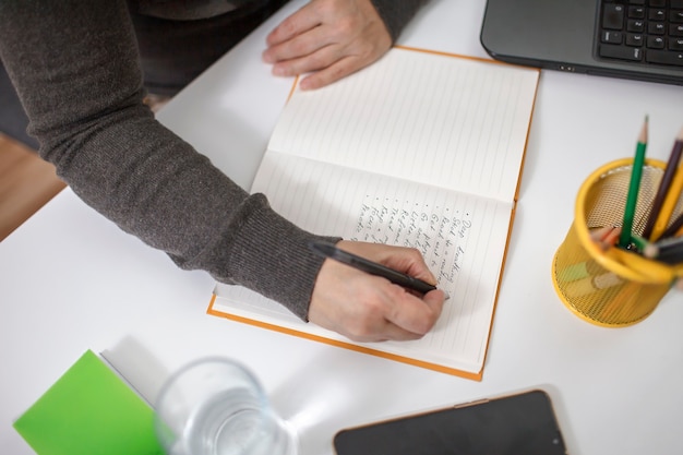 Photo woman writing on notebook a list of rules for mental health